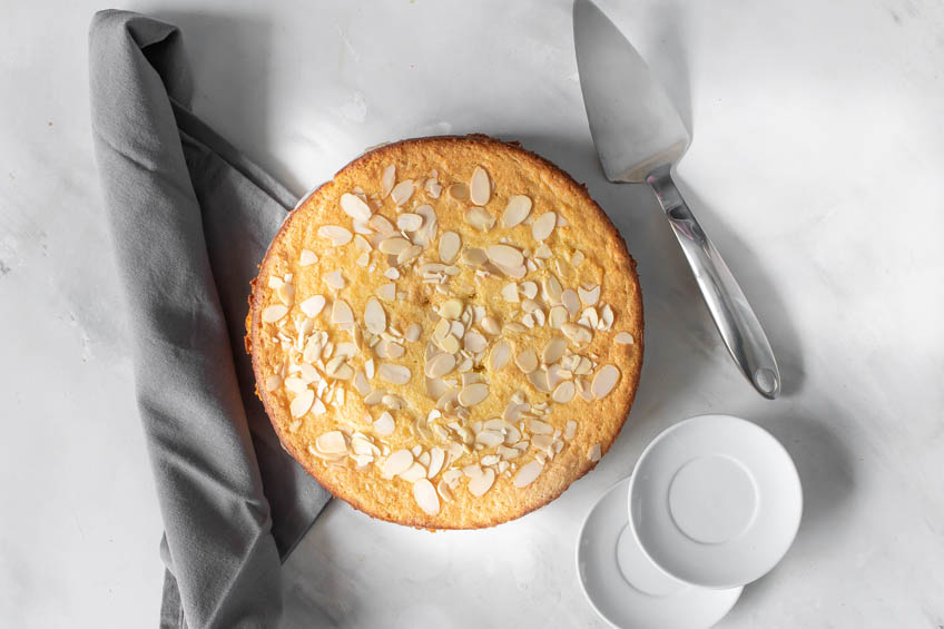 An almond ricotta cake on a marble countertop