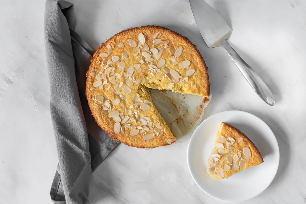 An almond ricotta cake with a slice taken out