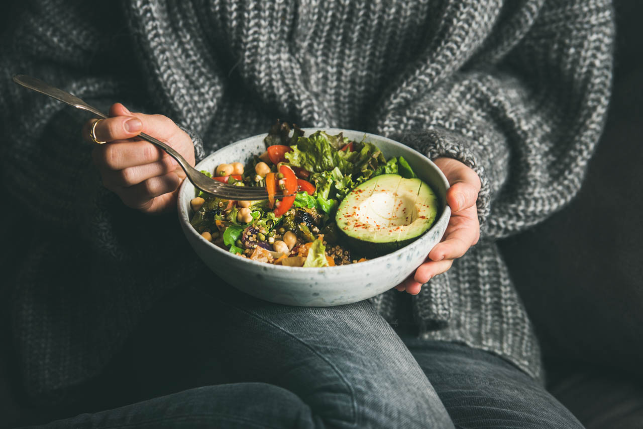 A woman's hands holding a bowl of salad
