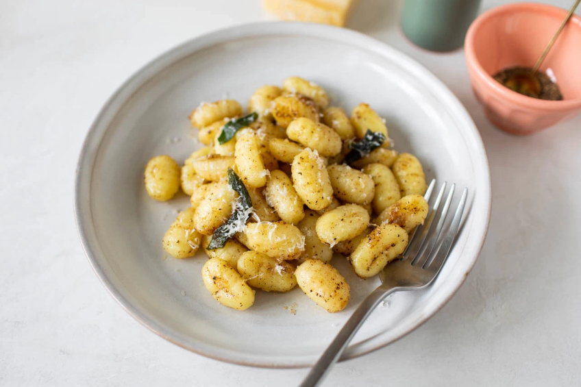 A plate of gnocchi with brown butter sage sauce