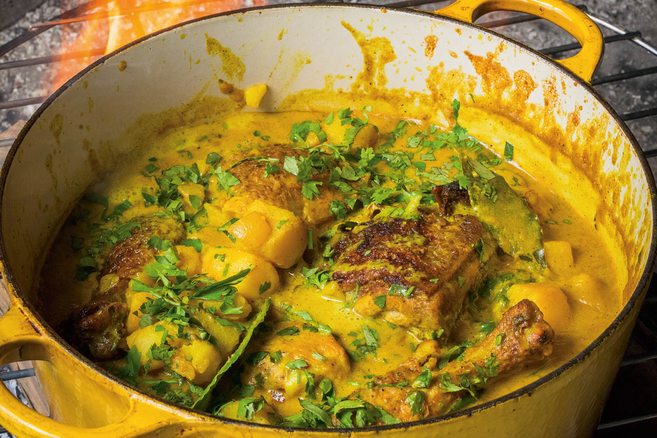 A closup of curry chicken in a Dutch oven