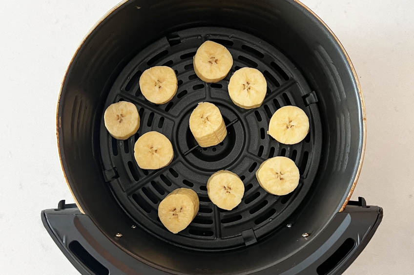 Plantain pieces in an air fryer basket