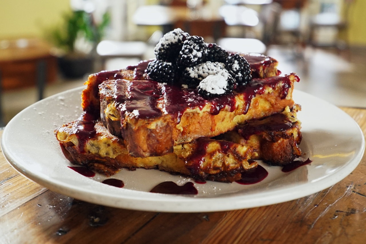 Two slices of blackberry custard French toast served on a white plate