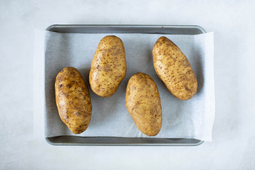 4 potatoes on a baking tray