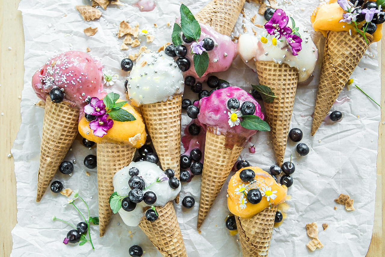 Ice cream in cones, decorated with berries and flowers.