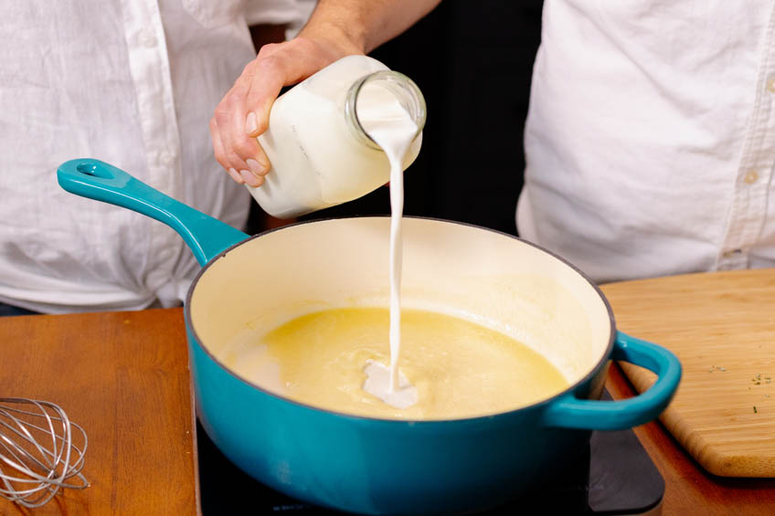 Milk being poured into Dutch oven