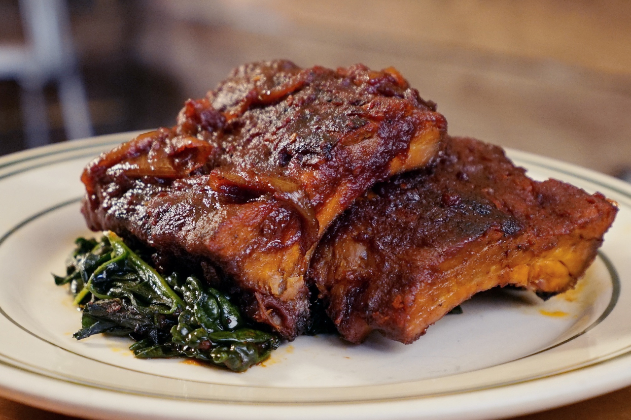 Pork ribs with a sticky sauce served with some greens