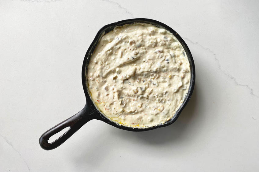 Mexican street corn dip mixture in a cast iron skillet