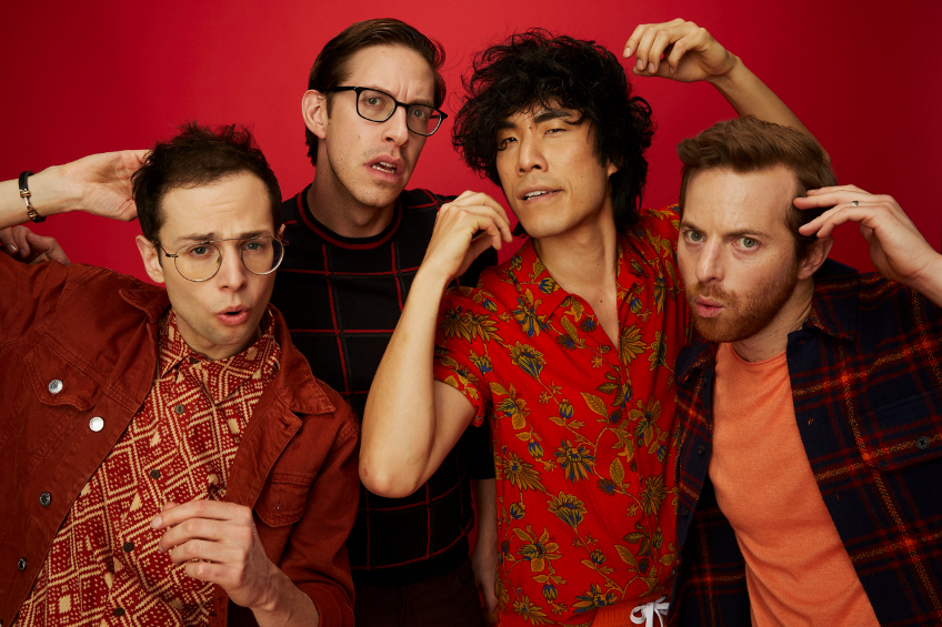 The Try Guys (Ned, Keith, Zach and Eugene) pose together on a red backdrop