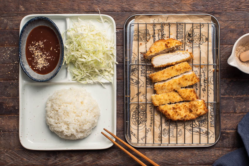 Air fryer chicken katsu being served alongside steamed rice and shredded cabbage.