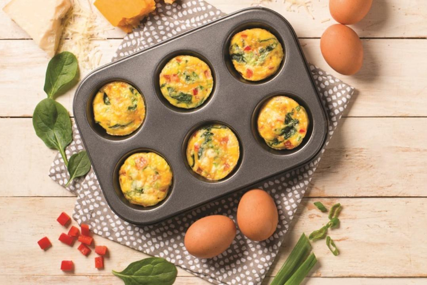 A muffin tin filled with baked egg cups