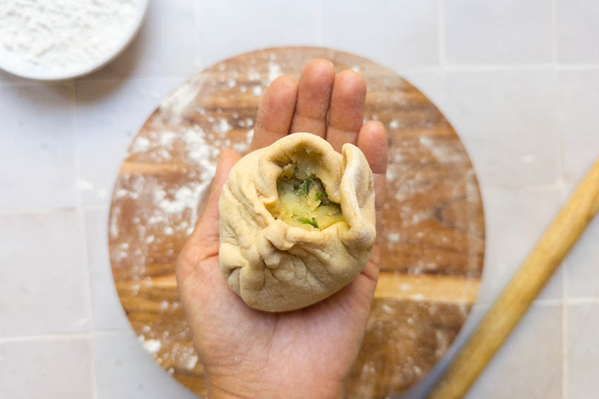 Dough ball for aloo paratha being pinched up