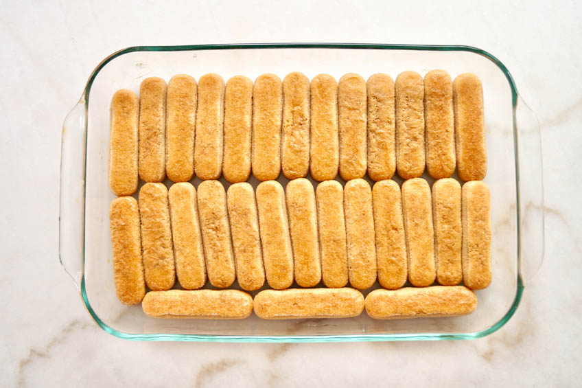 Espresso-soaked lady fingers in a casserole dish