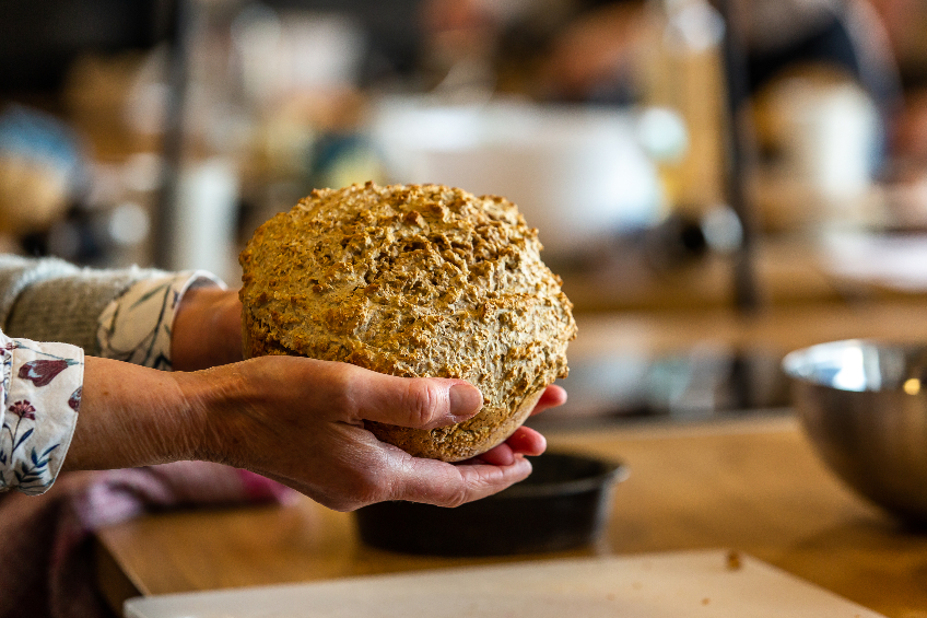 A person holding a loaf of Irish soda bread