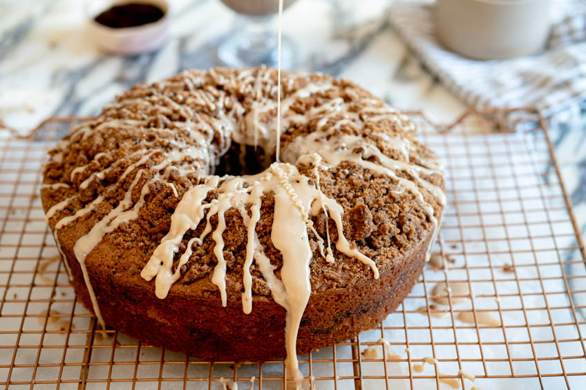 Vietnamese coffee cake being drizzled with sweetened condensed milk glaze