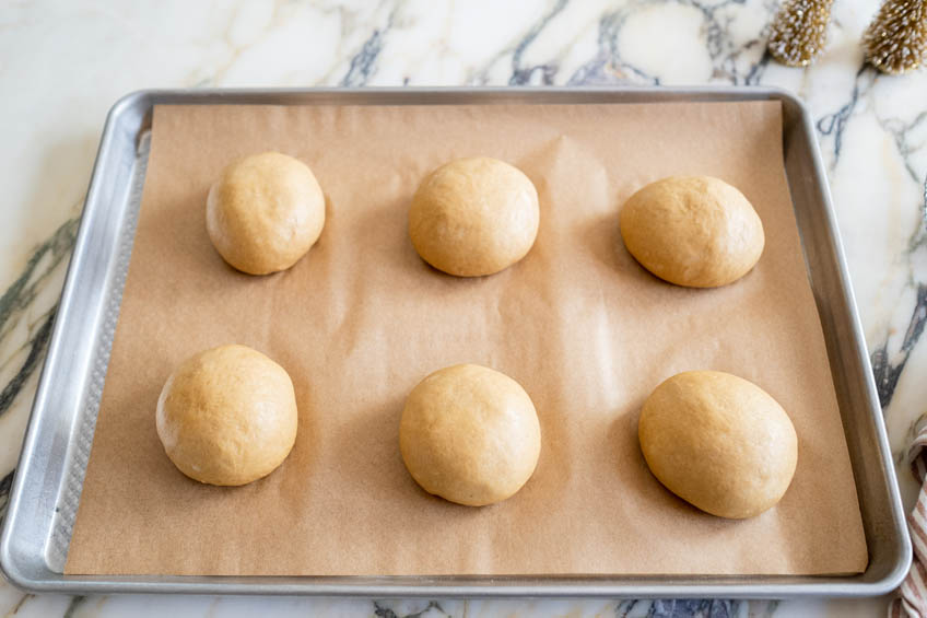 Donut dough balls on a baking sheet
