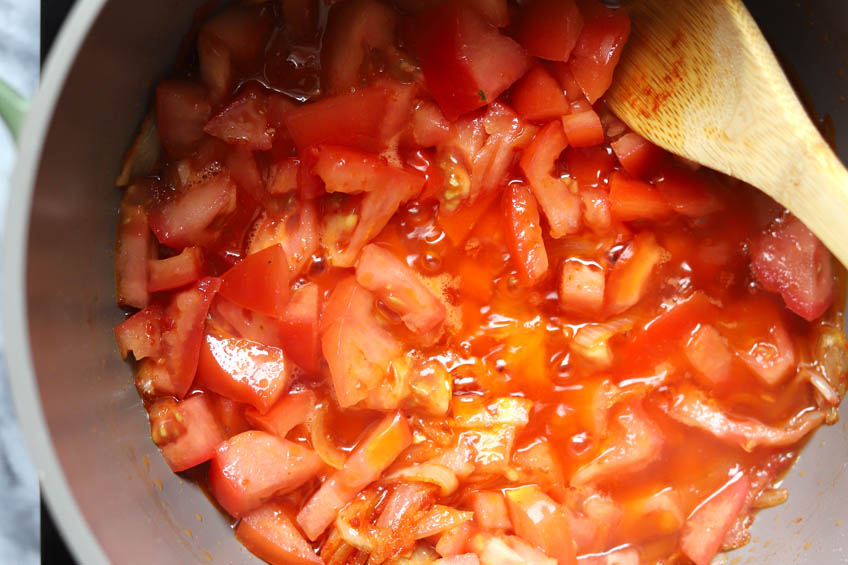 Tomatoes and onions simmering in a Dutch oven