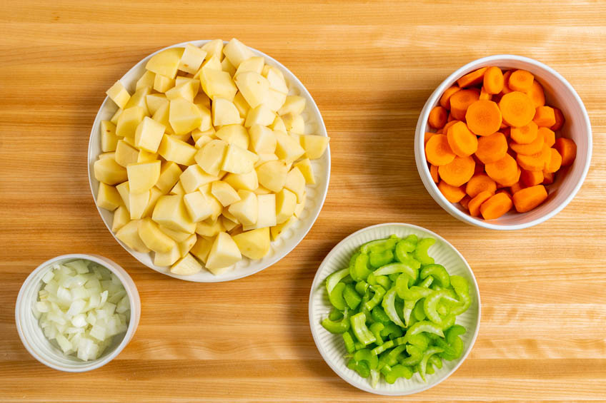 Onions, potatoes, celery and carrots in bowls