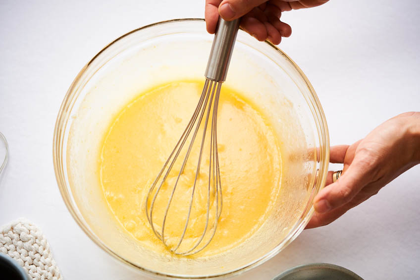 A glass bowl with a sweet cookie batter being whisked