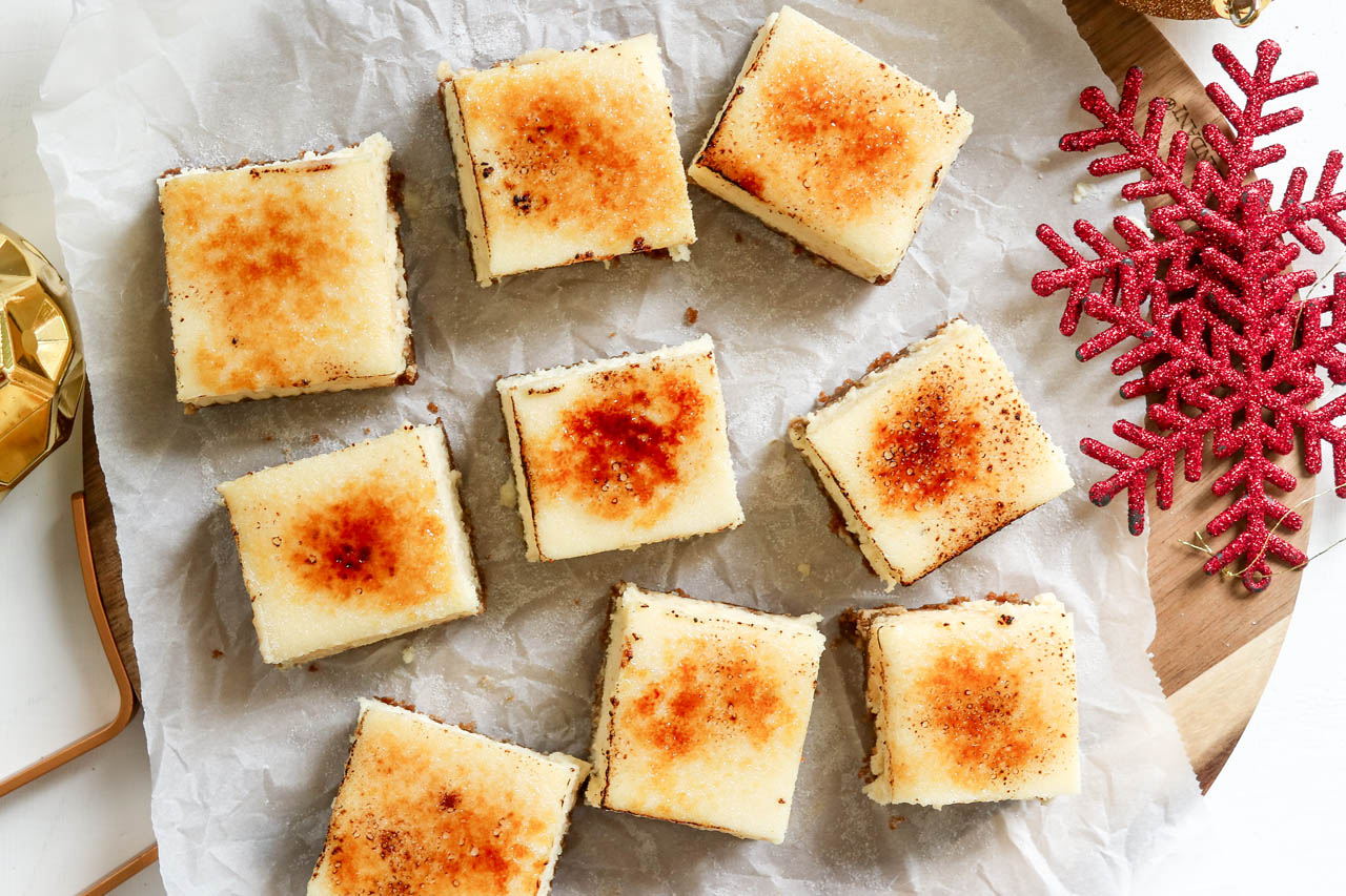 Eggnog brulee cheesecake bars on parchment paper