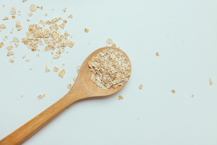 Uncooked oats and a wooden spoon