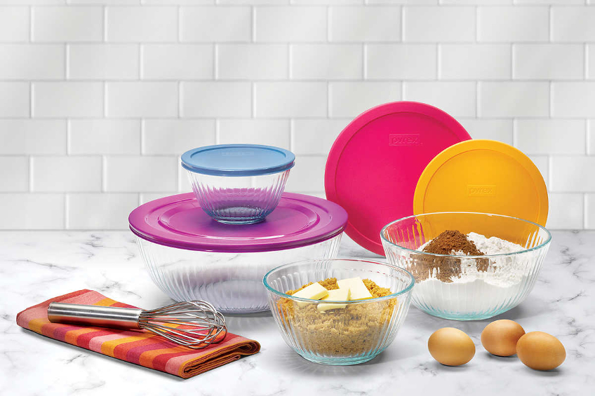 A set of glass Pyrex mixing bowls with colourful plastic lids