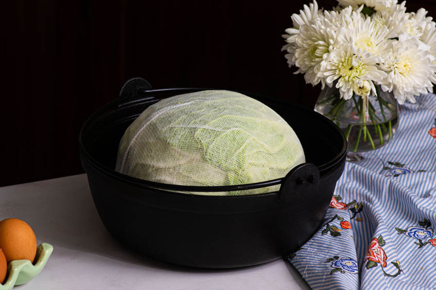 Jumbo cabbage roll meatloaf wrapped in cheese cloth in a Dutch oven