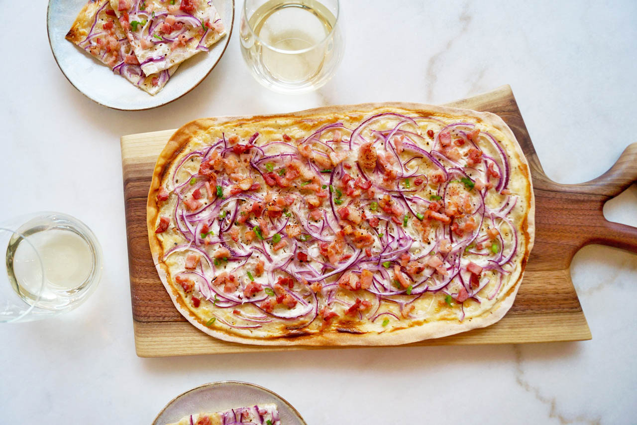 German flammkuchen flatbread pizza on a serving board