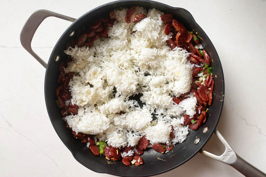 Rice, lap cheong, scallions, and garlic in a large skillet.