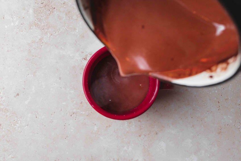 Vegan hot chocolate being poured into a mug
