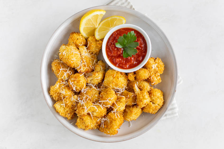 Air fryer cauliflower bites with a side of marinara for dipping
