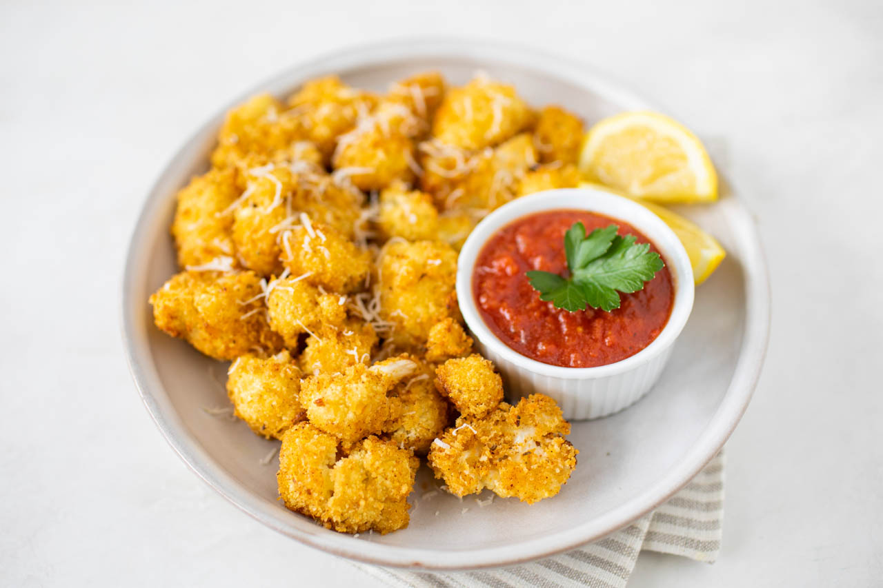 Air fryer cauliflower bites with a side of marinara for dipping