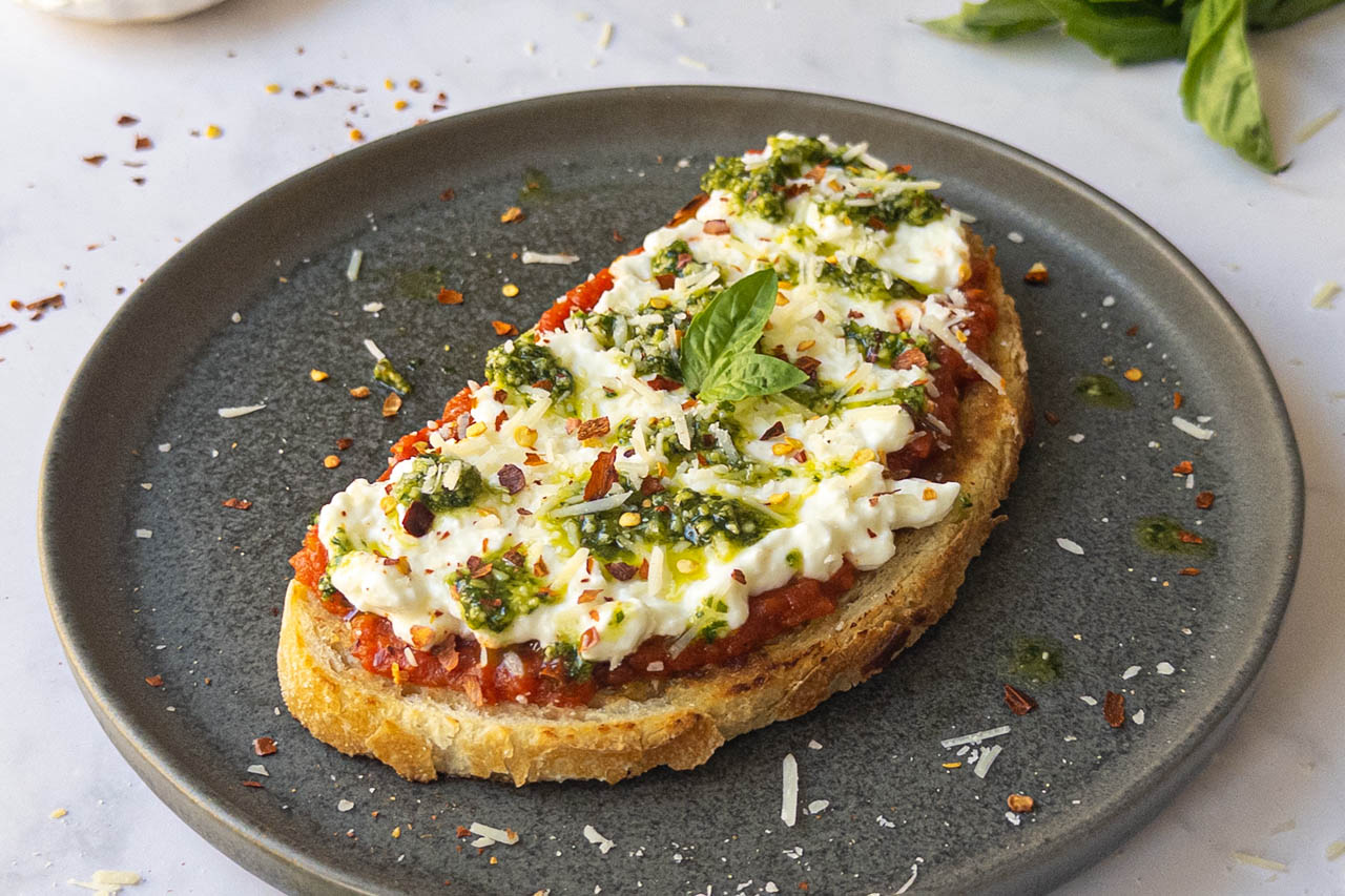 A closeup of cottage cheese pizza toast on a plate
