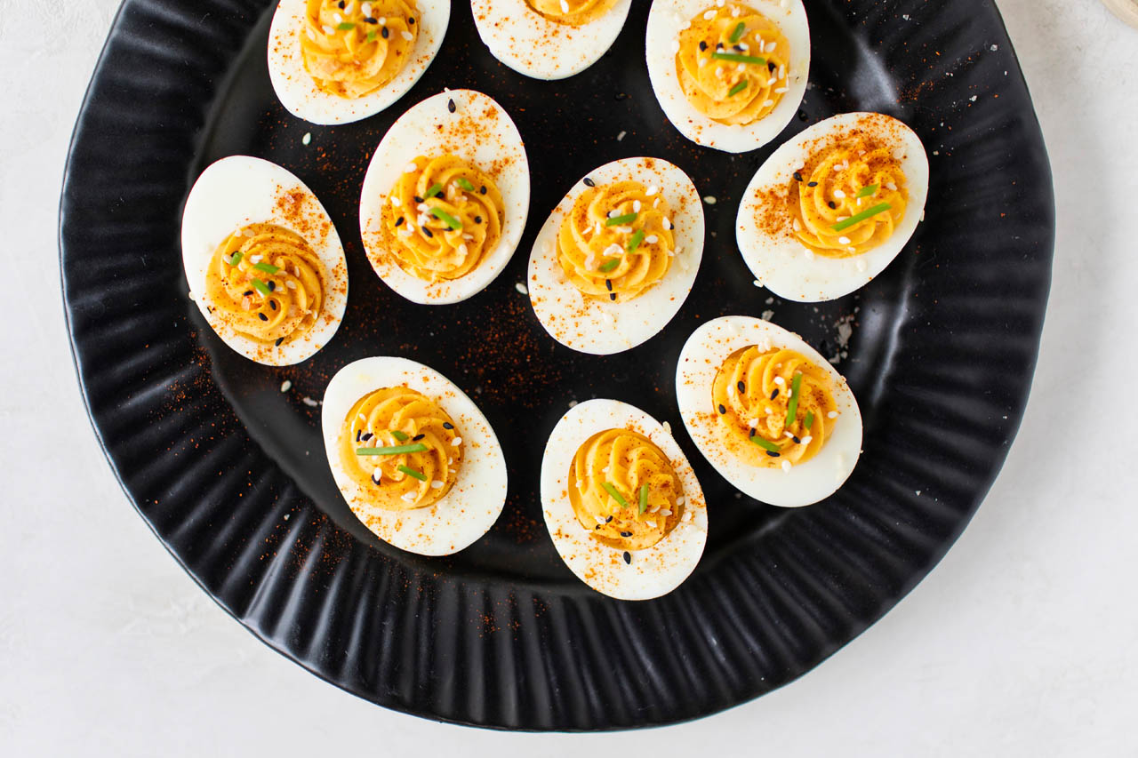 A closeup on a plate of honey-sriracha devilled eggs