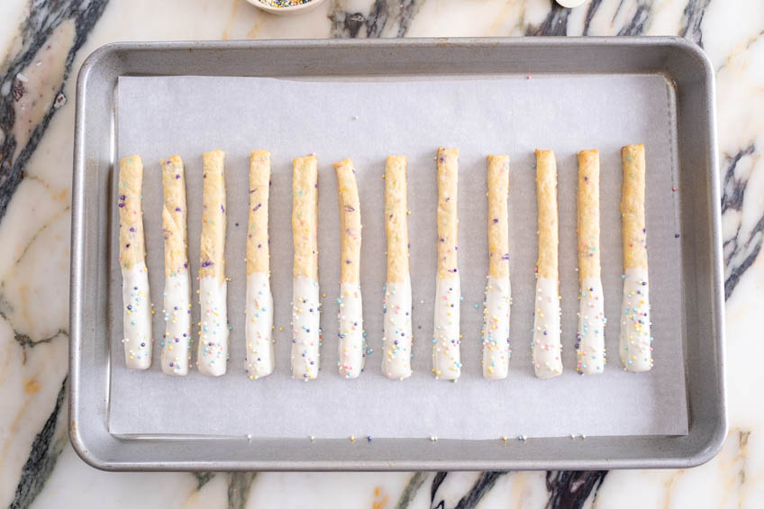 Birthday cake cookie sticks on a baking sheet