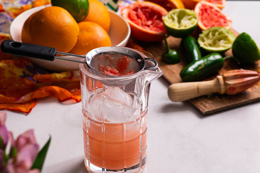 Grapefruit juice being strained into a glass