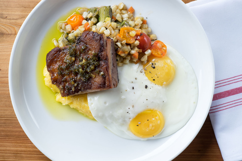 A brunch dish of brisket, grits and sunny side eggs at Edumund's Oast in Charleston, South Carolina