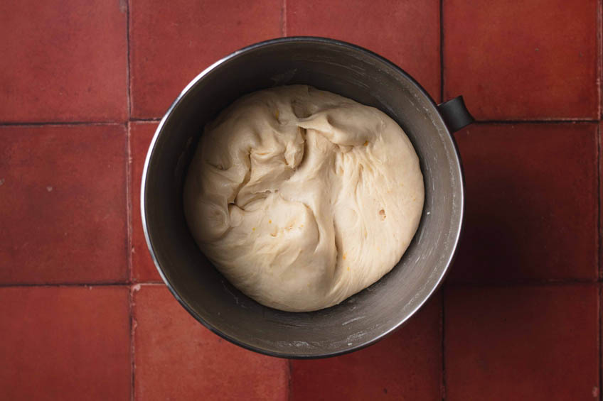 Risen dough for vegan malasadas in a mixing bowl