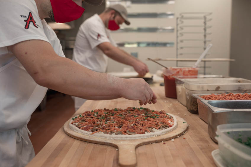 A Windsor pizza being prepped