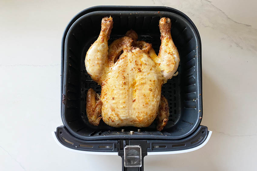 A chicken in an air fryer basket
