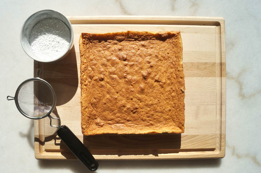 A baked magic custard cake on a cutting board.