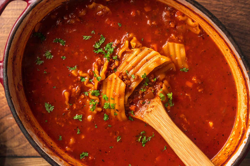Creamy vegan lasagna soup topped with parsley in a Dutch oven