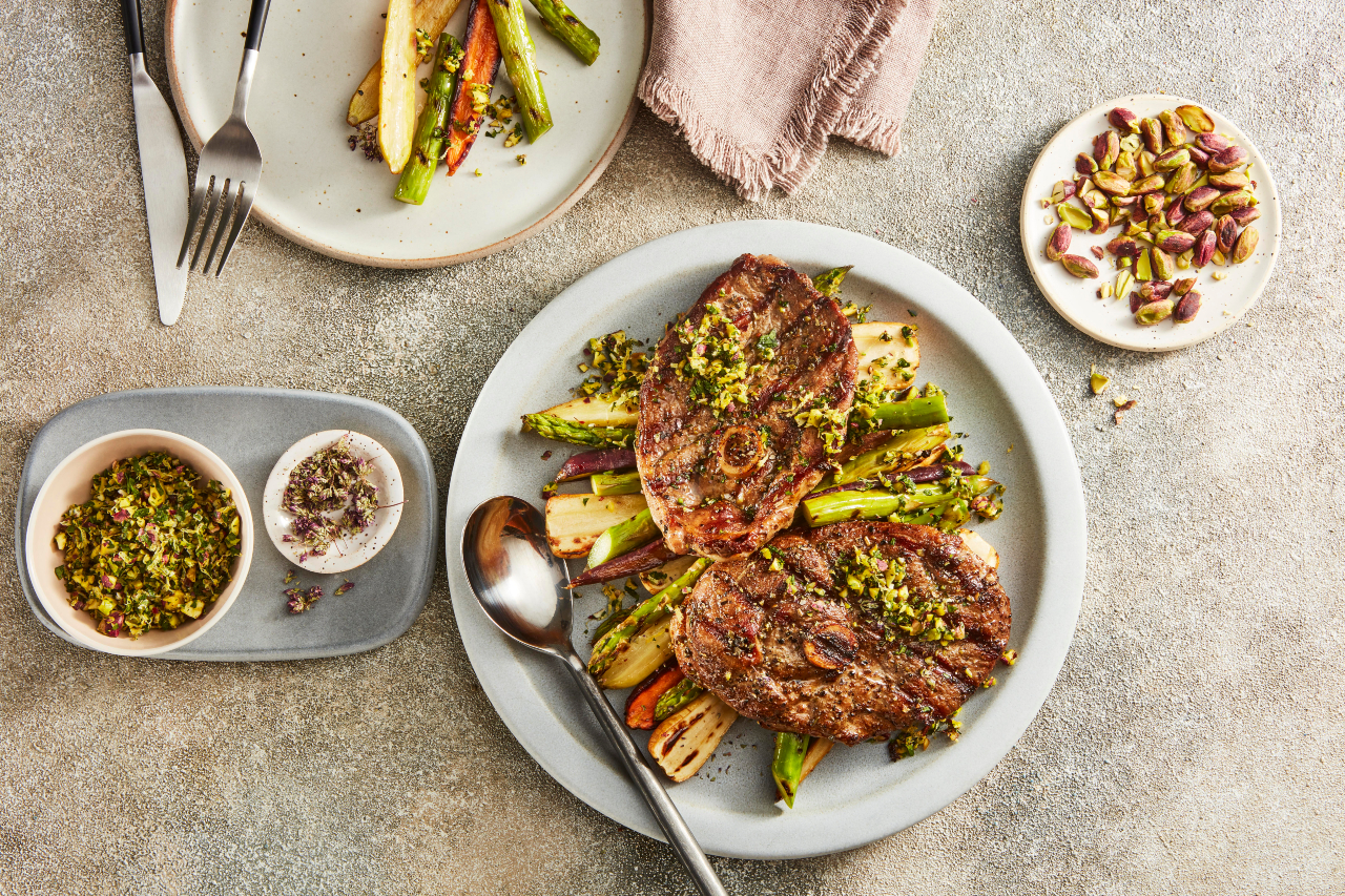 Grilled lamb steaks on a bed of asparagus.