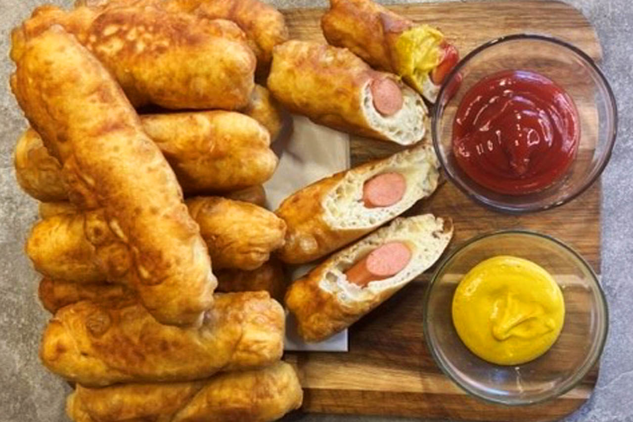 Bannock dogs on a serving board with ketchup and mustard