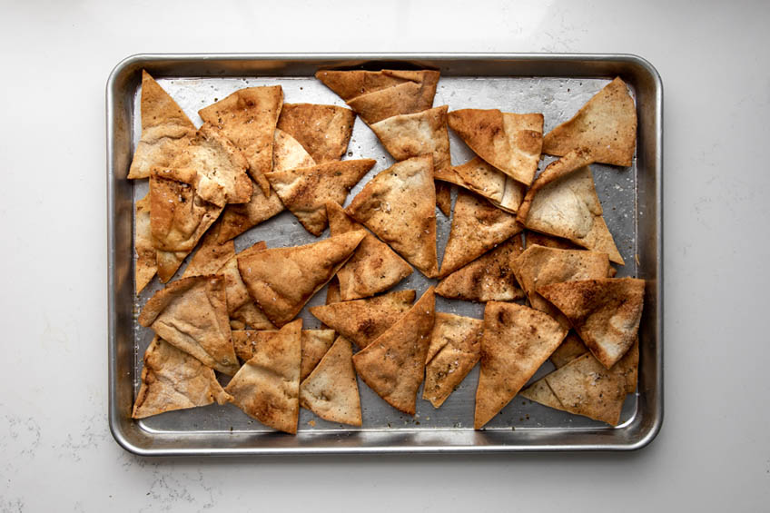 Baked pita chips on a baking sheet