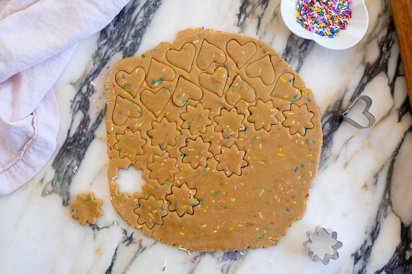Cookies being cut out from funfetti cookie dough