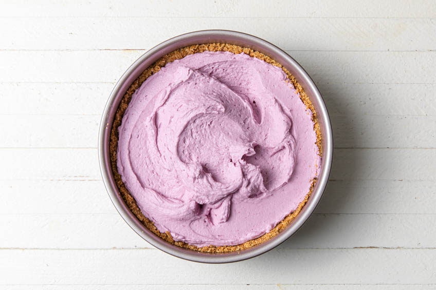 Ube filling unevenly spread in a graham cracker crust