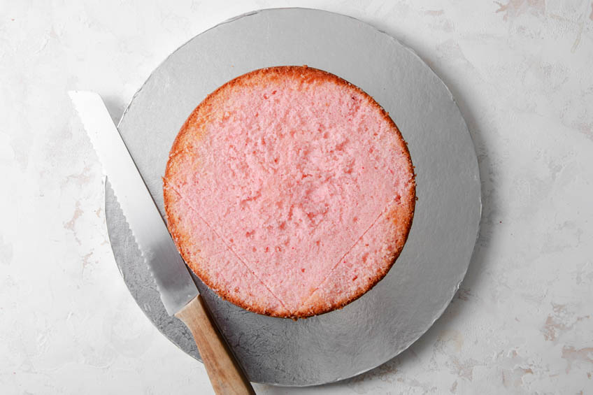A pink cake with the top trimmed off