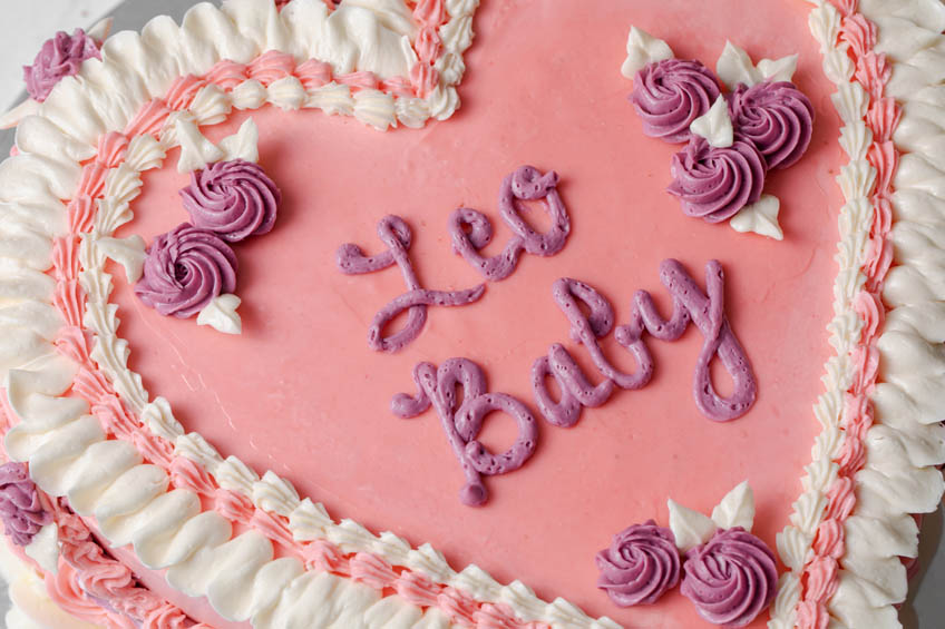A closeup on a baddie birthday cake that says "Leo Baby"