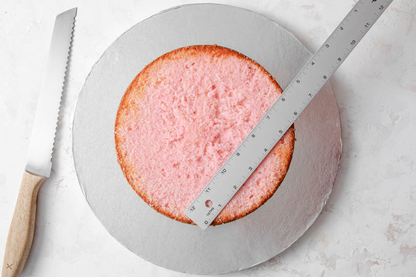 A cake with a ruler on top to cut it into a heart